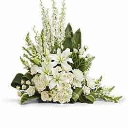 White lily and rose floral arrangement with tall greenery