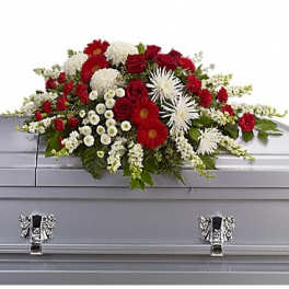 Red and white floral spray on a silver casket