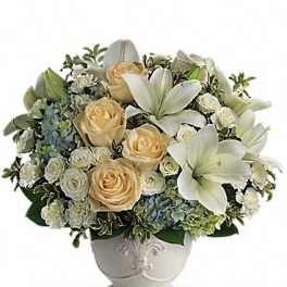 White lilies and cream roses arranged in a decorative vase