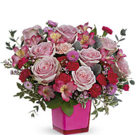Pink roses and mixed flowers in a magenta vase