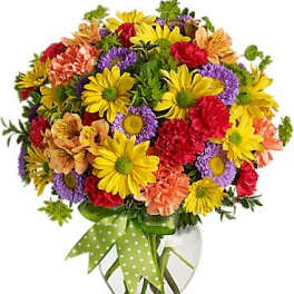 Colorful mixed bouquet in a clear glass vase with a green polka-dot ribbon