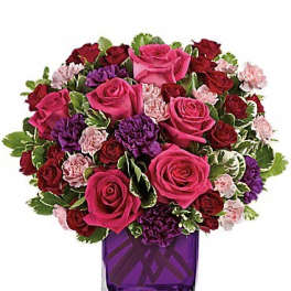 Pink and red rose bouquet in a purple glass vase