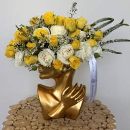 Yellow and white rose bouquet in a gold sculptural vase