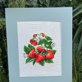 Framed cross-stitch of red strawberries and green leaves