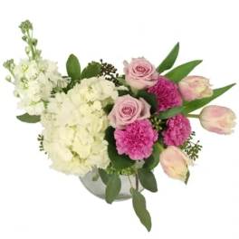 Pink roses and carnations with white hydrangeas in a glass vase