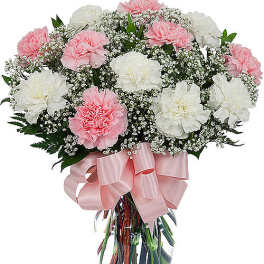 Pink and white carnations in a glass vase with a pink ribbon
