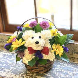 White teddy bear floral basket with colorful flowers and a red bow