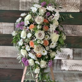 Standing floral spray with white roses, daisies, and purple accents