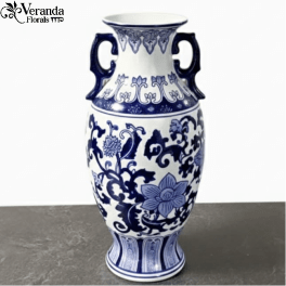 Tall blue and white ceramic vase with handles and floral pattern