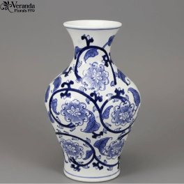 White ceramic vase with blue floral pattern and curved silhouette on a gray background