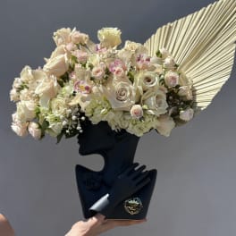 Cream rose bouquet with orchids and hydrangeas in a black holder