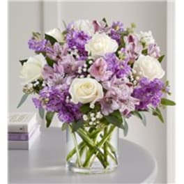 Purple and white bouquet in a clear glass vase