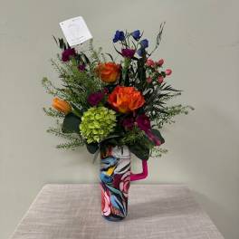 Colorful bouquet in a patterned mug-style vase
