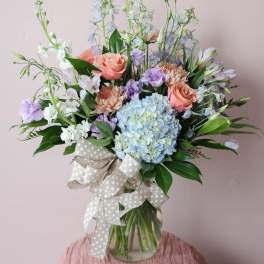 Pastel bouquet with hydrangea, roses, and lilies in a glass vase