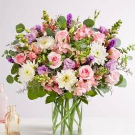 Pink roses and white daisies in a clear glass vase