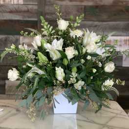 White roses and lilies arranged in a white vase