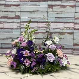 Low floral arrangement with purple, pink, and white blooms