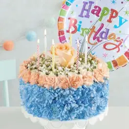Birthday cake-shaped flower arrangement with candles and a balloon