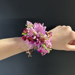 Pink flower wrist corsage on a person's wrist