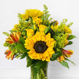 Yellow sunflower and rose bouquet in a clear glass vase