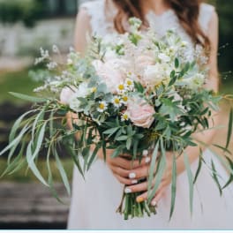 Bride holding a loose bouquet of pale pink and white flowers