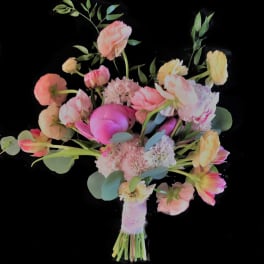 Pink and peach bouquet with mixed blooms and eucalyptus on a black background