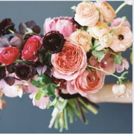 Bouquet of pink, peach, and dark burgundy flowers