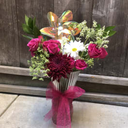 Bouquet of pink roses and a white daisy in a glass vase