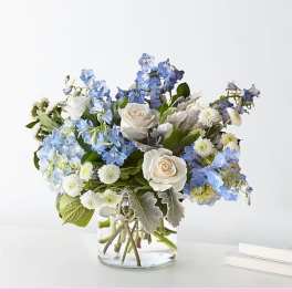 Blue and white flower arrangement in a clear glass vase