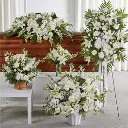 White floral funeral arrangements displayed around a casket
