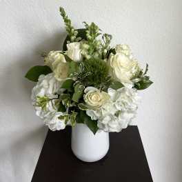 White roses and hydrangeas in a white vase