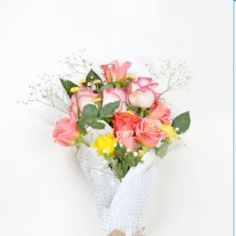 Bouquet of pink and yellow roses wrapped in white paper