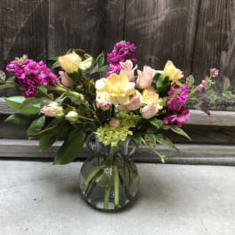 Bouquet of pink and yellow flowers in a clear glass vase