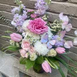 Pink and lavender bouquet with roses, tulips, and a butterfly accent