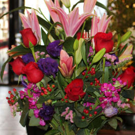 Bouquet of pink lilies and red roses with purple flowers