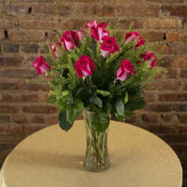 Pink roses in a clear glass vase on a table