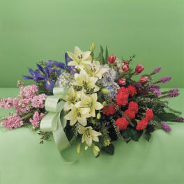 Mixed bouquet with lilies, tulips, and carnations on a green background