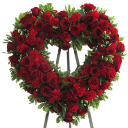 Heart-shaped red rose wreath on a stand