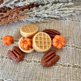 Decorative faux pumpkins and pecans on burlap fabric