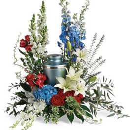 Floral arrangement around a blue urn with red, white, and blue flowers