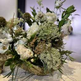 White floral arrangement in a rustic wooden container