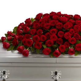 Large spray of red roses on a white casket