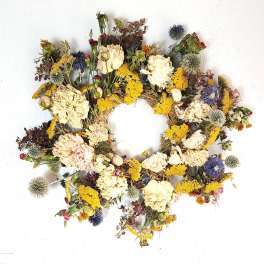 Dried floral wreath with cream, yellow, and purple blooms