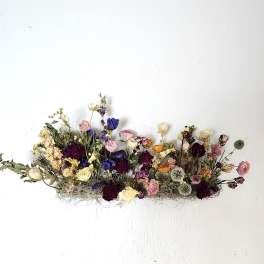 Dried flower arrangement with roses and poppy-like blooms in mixed colors