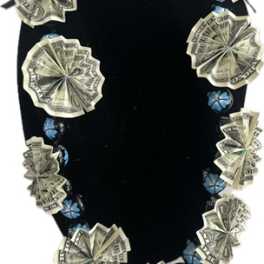 Black velvet necklace display with dollar-bill rosettes and blue bead accents