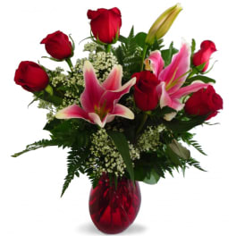 Red roses and pink lilies in a red glass vase