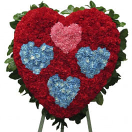 Heart-shaped floral standing spray with red, pink, and blue flowers