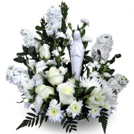 White floral arrangement with a small religious statue in the center