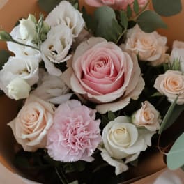 Bouquet of pink and white roses with eucalyptus in tan wrap