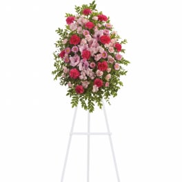 Pink and red floral standing spray on a white easel